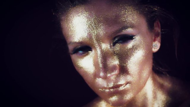 4k Studio Shot of a Golden Glittery Face Woman