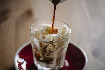 delicious fresh morning espresso pouring into vanilla ice cream, making an Affogato dessert