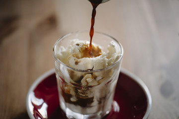 delicious fresh morning espresso pouring into vanilla ice cream, making an Affogato dessert