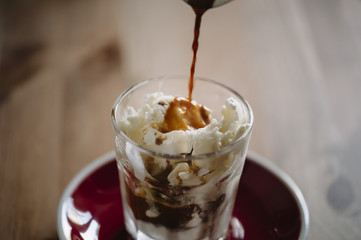 delicious fresh morning espresso pouring into vanilla ice cream, making an Affogato dessert