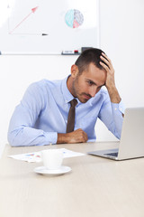 Stressed businessman working at his desk in his office