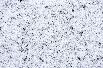 Ice and snow formed over the frozen water surface on the pond in winter