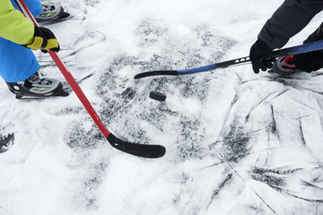 Naklejka premium A group of children playing ice hockey at the skating rink outside in winter.