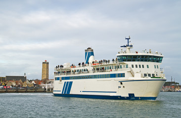 Ferry leaving harbor, in the background the lighthouse ‘Brandaris’ on the dutch island Terschelling