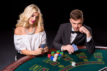 View of young, confident, man with the lady while he's playing poker game.