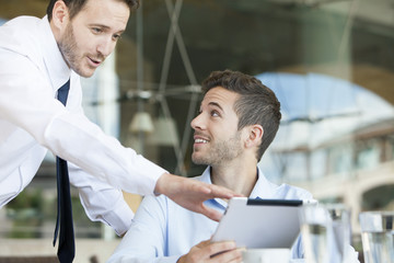 Businessmen collaborating project using digital tablet