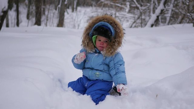 a funny child plays in the snow