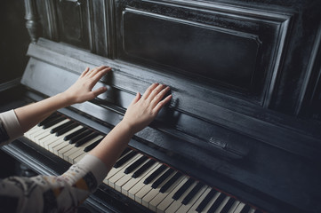 The girl plays piano, close up , white and black keyboard