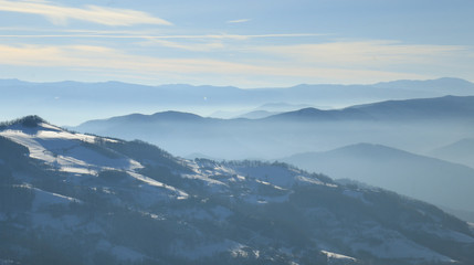 Obraz na płótnie Canvas Mountain layer in morning sun ray and winter fog.