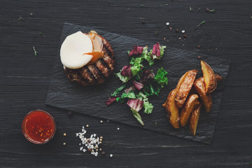 Grilled beef steak on dark wooden table background, top view