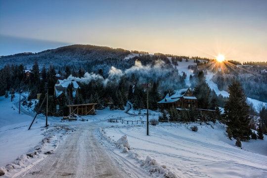 winter landscape in mountainous rural area at sunset