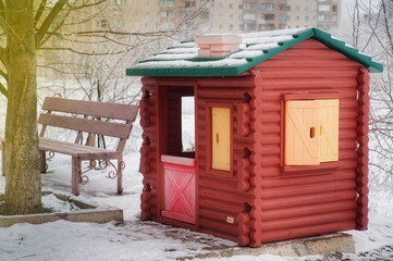 Fototapeta na wymiar small children's house is on the street covered with snow, winte