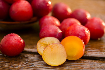 Fresh bright plums on wooden background
