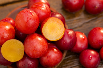 Fresh bright plums on wooden background