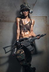 Naklejka premium The woman - a soldier with a gun near the wall