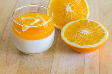 Orange Panna Cotta and Orange on Wooden background.