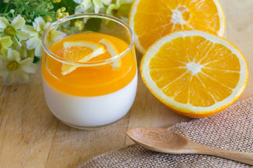 Orange Panna Cotta and Orange on Wooden background.