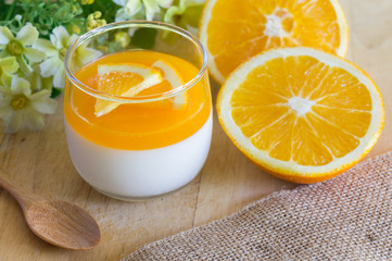 Orange Panna Cotta and Orange on Wooden background.