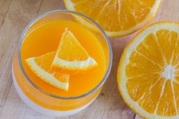 Orange Panna Cotta and Orange on Wooden background.