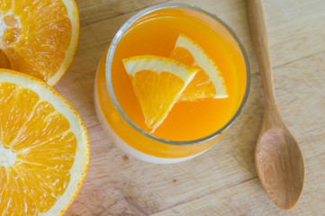 Orange Panna Cotta and Orange on Wooden background.