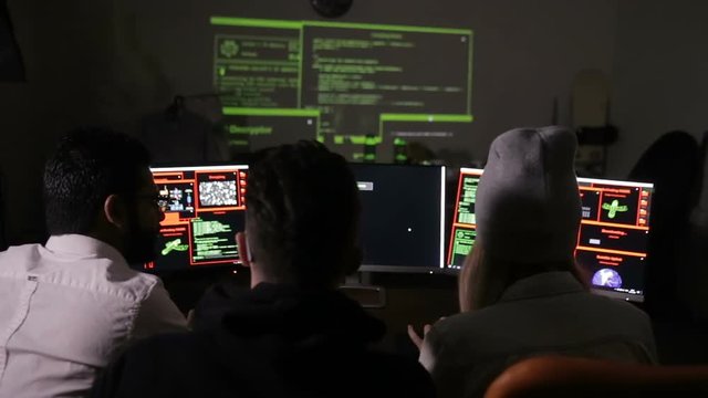 Young hacker team working on a computer. Cybercrime, cyber attack concept. HD.