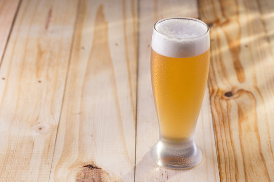 Tulipa de chopp gelado em mesa de madeira