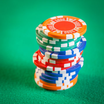 Poker chips stacked on green table