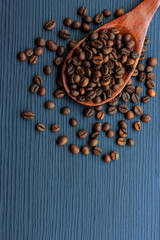 Coffee beans and wood spoon on dark wood background