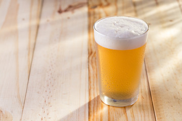Copo de chopp gelado em mesa de madeira