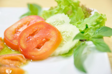 Tomatoes and lettuce on white plate.