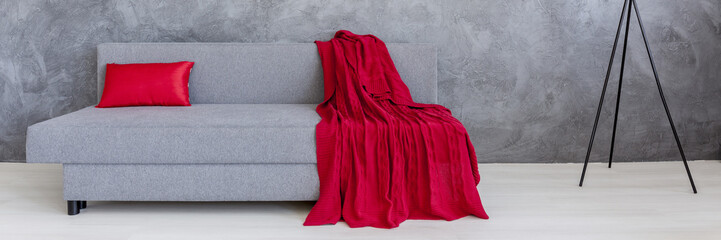 Grey sofa with red blanket