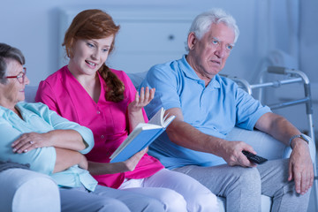 Caregiver reading book to patients