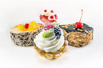 four mini cake with cream and berries