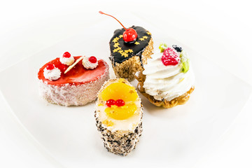 four mini cake with cream and berries
