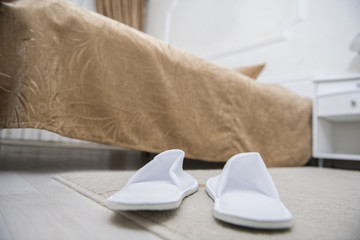 Fototapeta na wymiar Hotel room slippers. Focus on slippers.