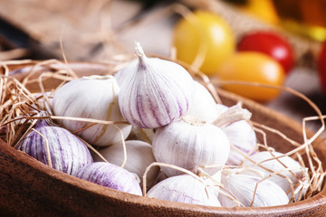 Small fresh garlic in a bowl. Vintage wooden background, selecti