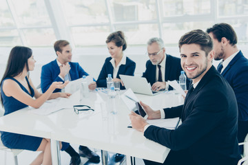 Fototapeta premium Portrait of happy successful businessman in glasses sitting at c