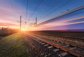 Fototapete Eisenbahn Hochgeschwindigkeits-Personenzug in Bewegung auf der Eisenbahn bei Sonnenuntergang. Verschwommener S-Bahn. Bahnhof gegen sonnigen Himmel. Eisenbahnreisen, Eisenbahntourismus. Ländliche Industrielandschaft. Konzept