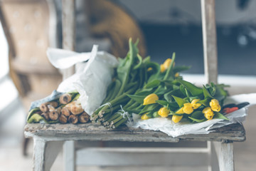 Yellow tulips flowers bouquet on a wooden table