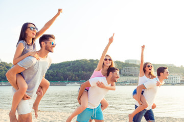 Group of happy young people having fun at the beach summer day