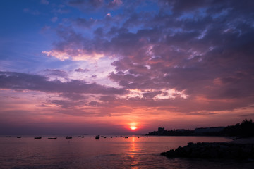 Sunset on the beach with fisherman boat