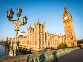  Big Ben and the Palace of Westminster. Low angle view of the famous clock tower London landmark in the early morning sun. © pxl.store