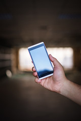 hand hold smart phone, cell phone, mobile over blurred image