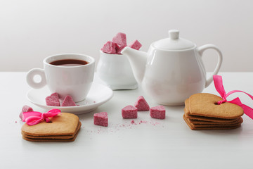 Granulated pink sugar  in the shape of heart and cup of tea  on