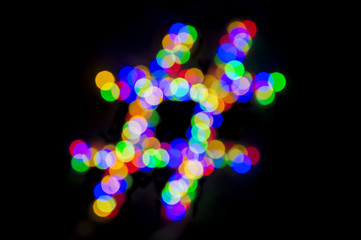 Abstract bokeh lights forming hashtag on black background