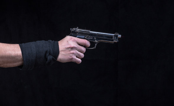 hand with gun isolated on a black background