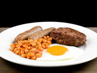 Cooked Breakfast or Meal of Fried Egg Sausages Baked Beans and a Hamburger