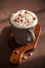cup of coffee with whipped cream and red hearts