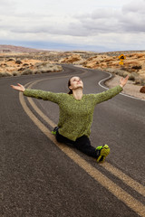 Young woman doing split on the road at Valley of Fire state Park, southern Nevada, USA
