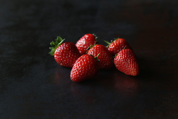 Tasty juicy strawberries on the dark background